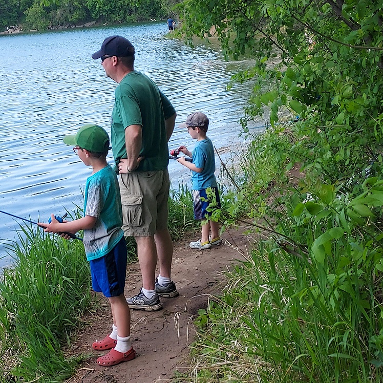 Kids fishing from shore at lake in Minnesota